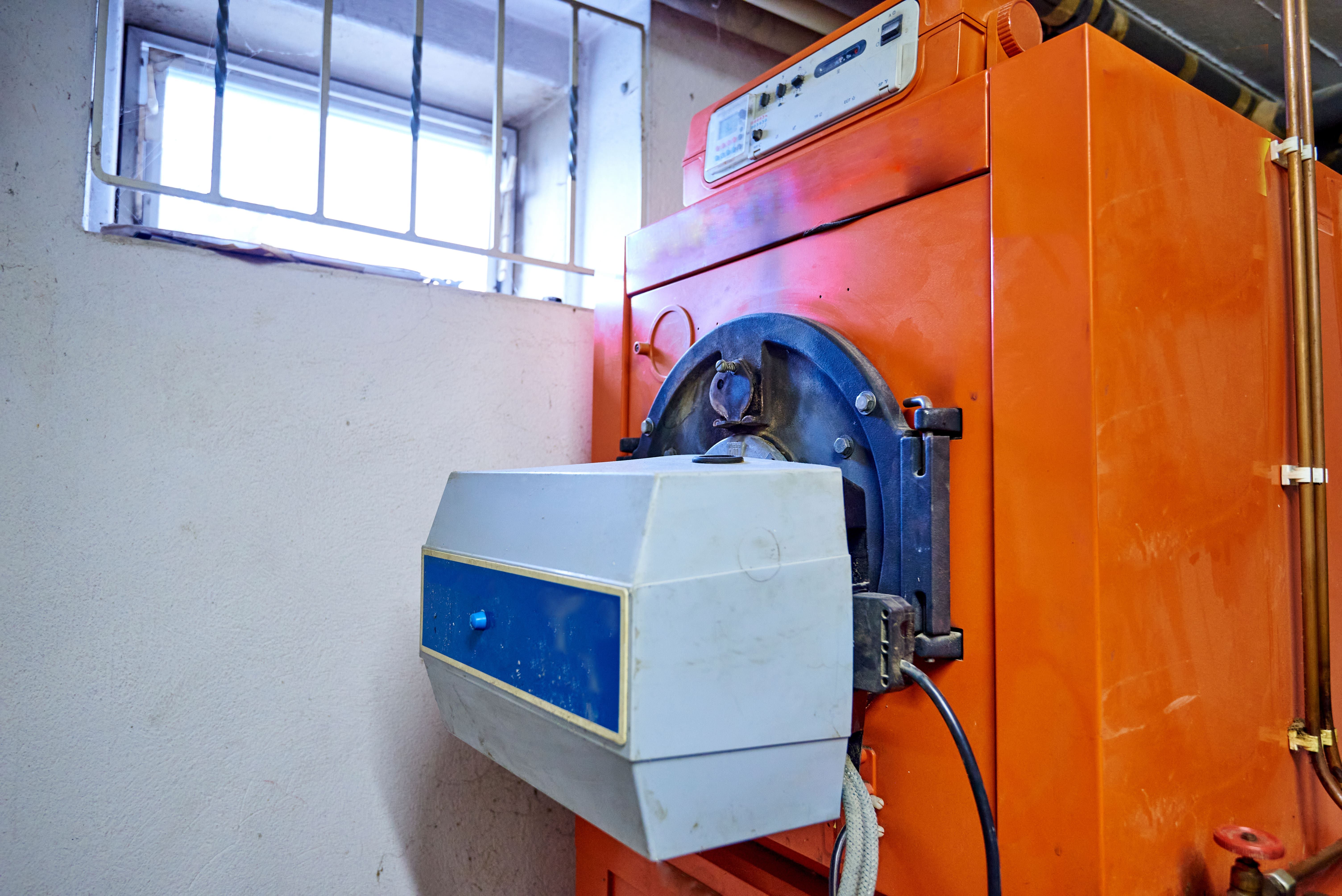 Ein alter orange-farbener Konstanttemperaturkessel, der unter die Sanierungspflicht fällt